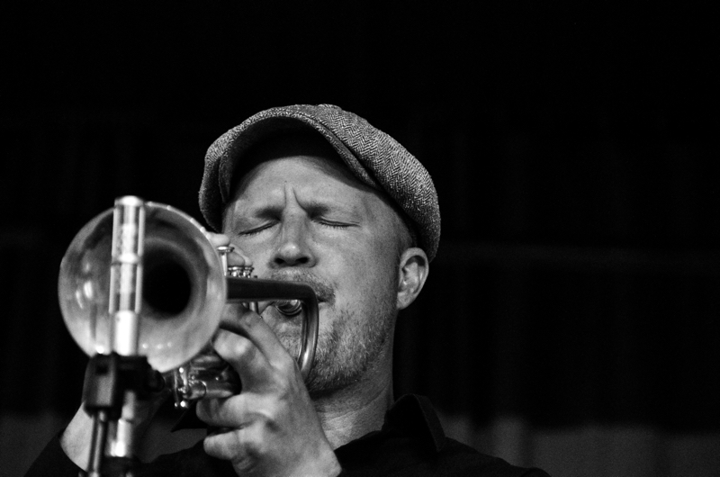Músico tocando la trompeta en un concierto de jazz.